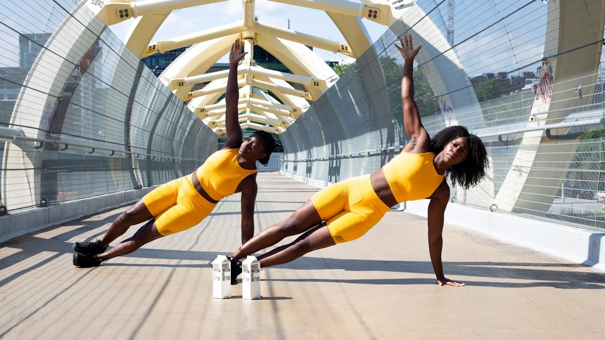 woman in yellow sports bra and yellow shorts jumping on white metal frame